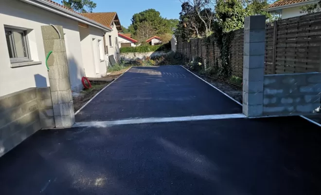 Travaux d'enrobés avec seuil et piliers de portail